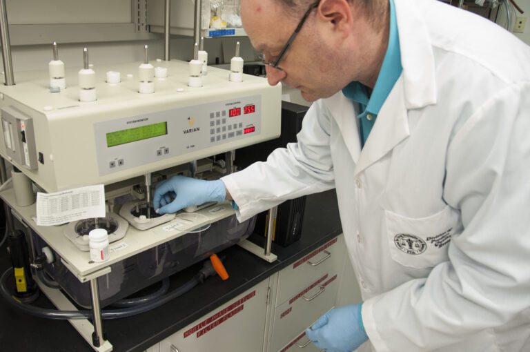 Chercheur testant la dissolution d'un comprimé dans un laboratoire pharmaceutique