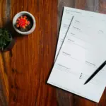 Factures papier et stylo posés sur une table en bois, illustration de la facturation des petites entreprises