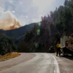 Camion de pompiers face à un panache de fumée d une feu de forêt