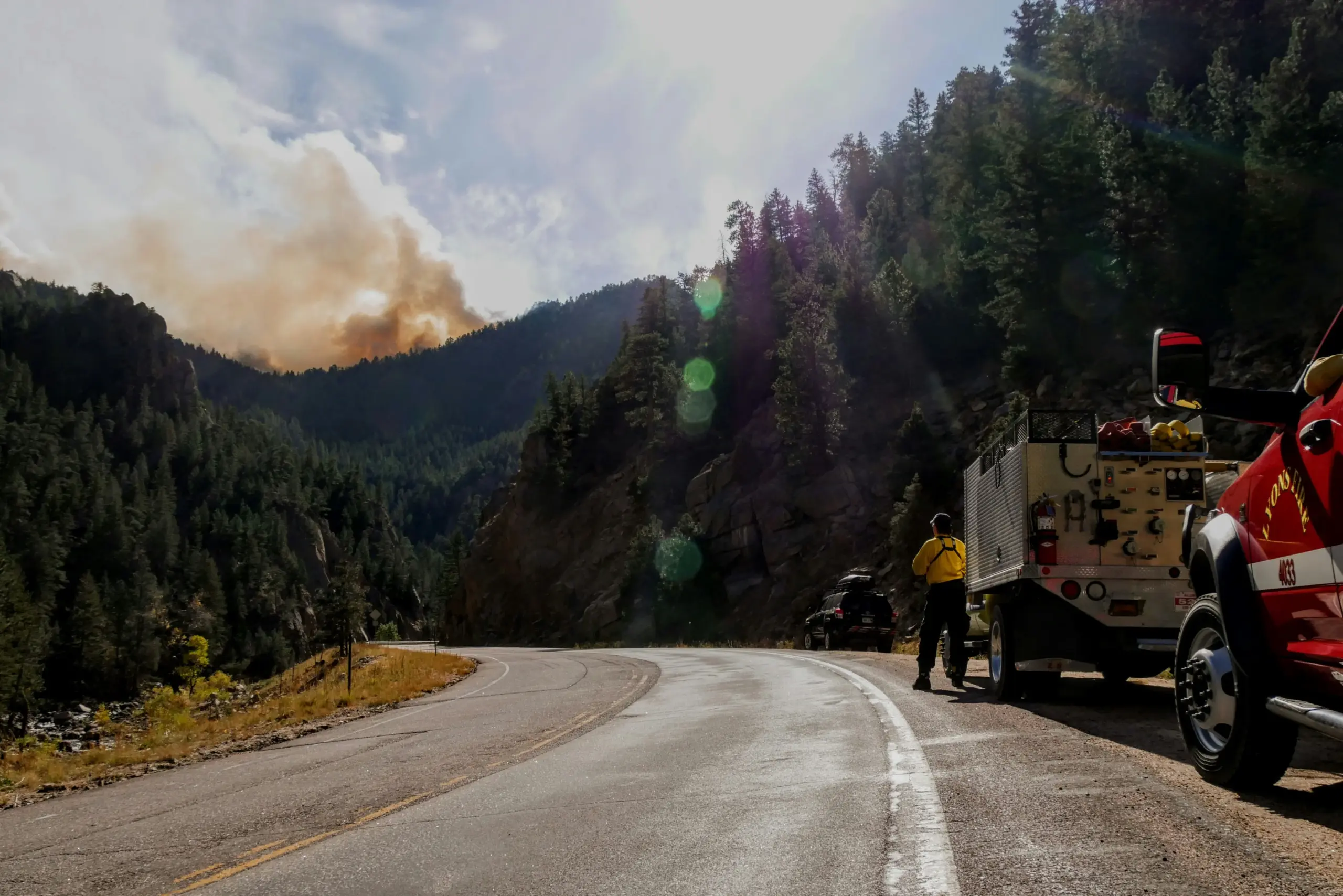 Camion de pompiers face à un panache de fumée d une feu de forêt