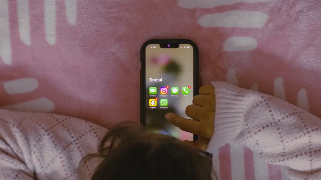 Une main tenant un téléphone affichant des applications de réseaux sociaux, illustration