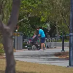 Une personne en fauteuil roulant accompagnée d'un aidant