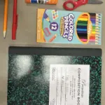 Fournitures scolaires : cahier, crayons, stylos et ciseaux