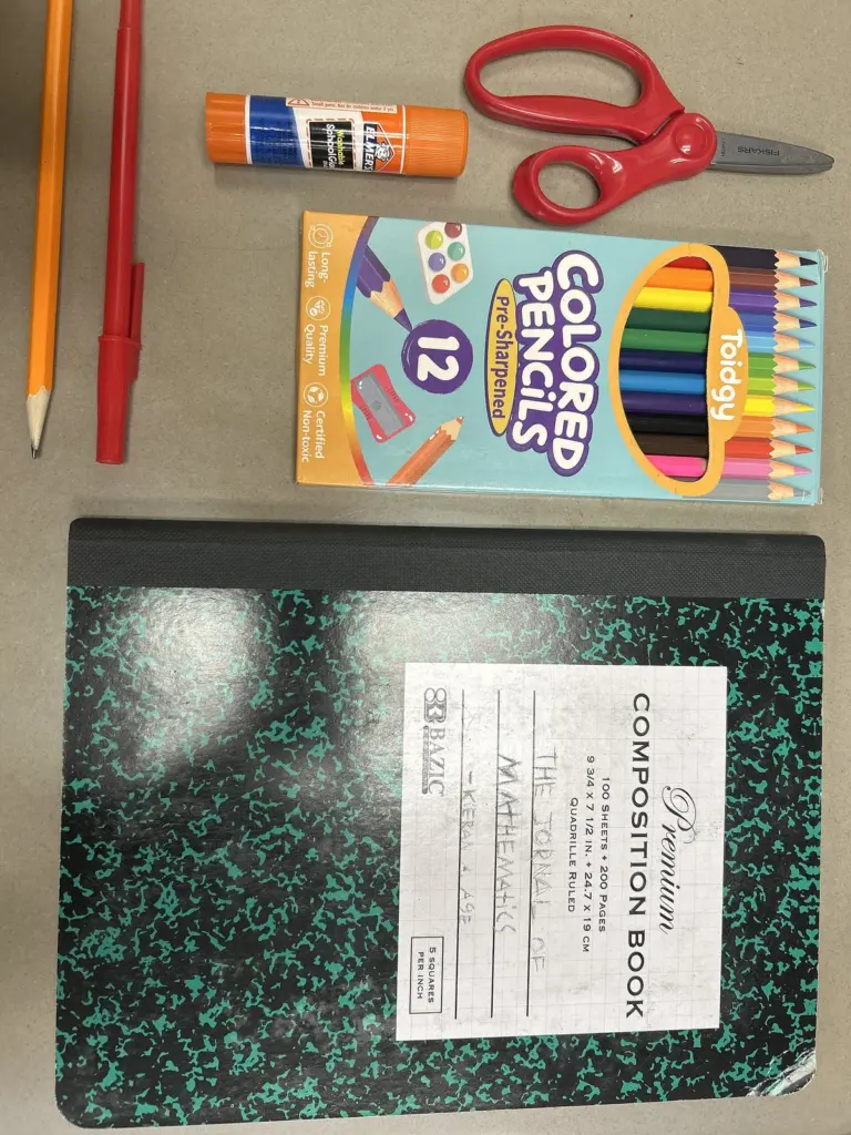 Fournitures scolaires : cahier, crayons, stylos et ciseaux