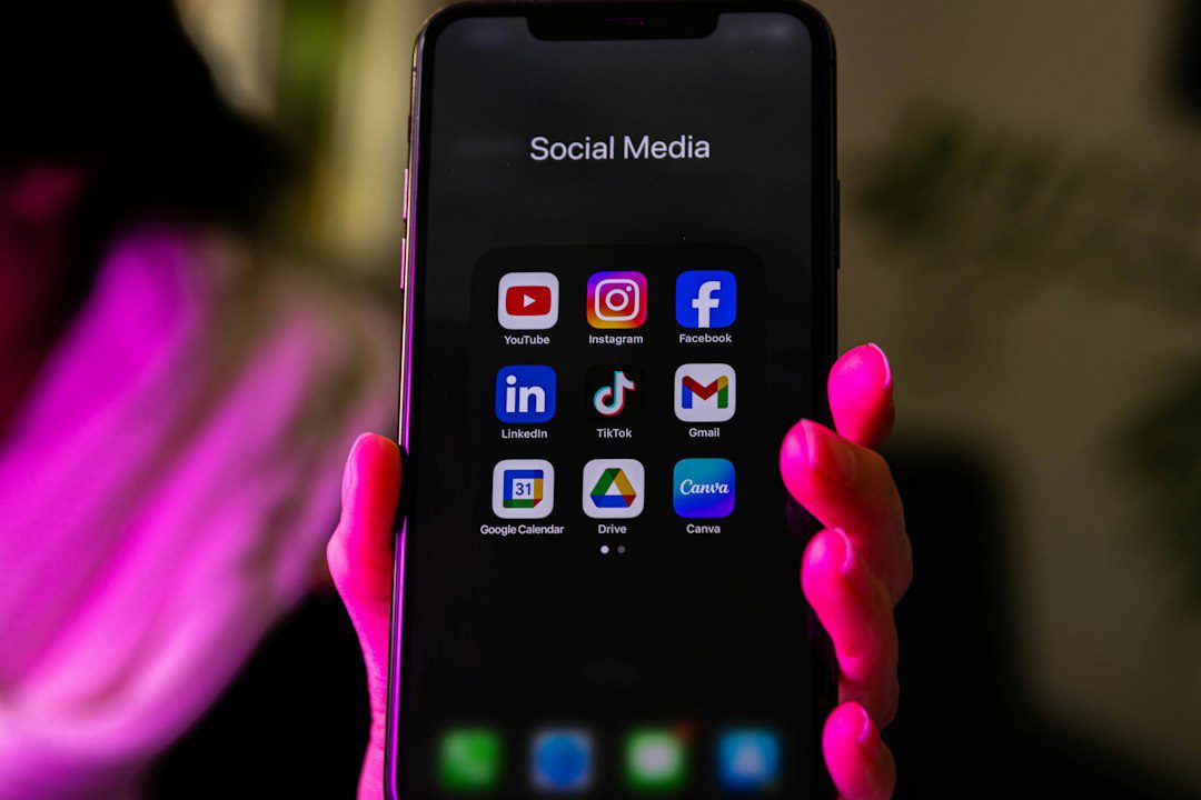 Smartphone affichant un dossier d'applications de réseaux sociaux, illustration de l'EU Kids Act