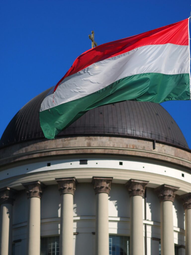 The hungarian flag flies over a domed building