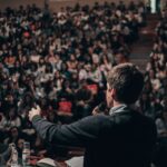 man speaking in front of crowd