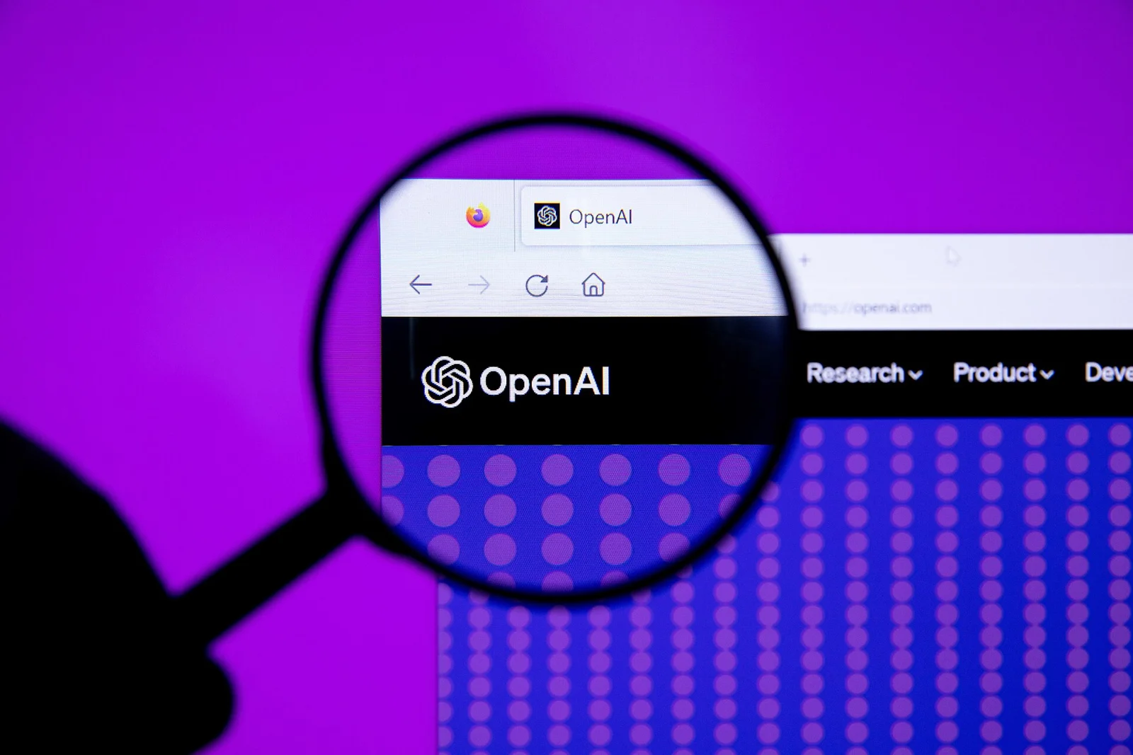 Logo d'OpenAI vu à travers une loupe