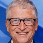 Portrait souriant de Bill Gates en costume, cadré en 16:9