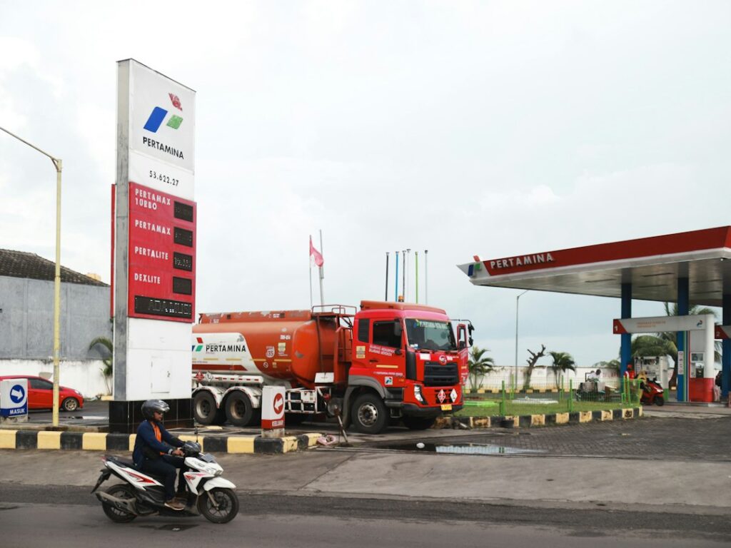 A red tanker truck at a gas station